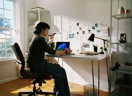 Someone using an AI voice assistant while working at a home desk